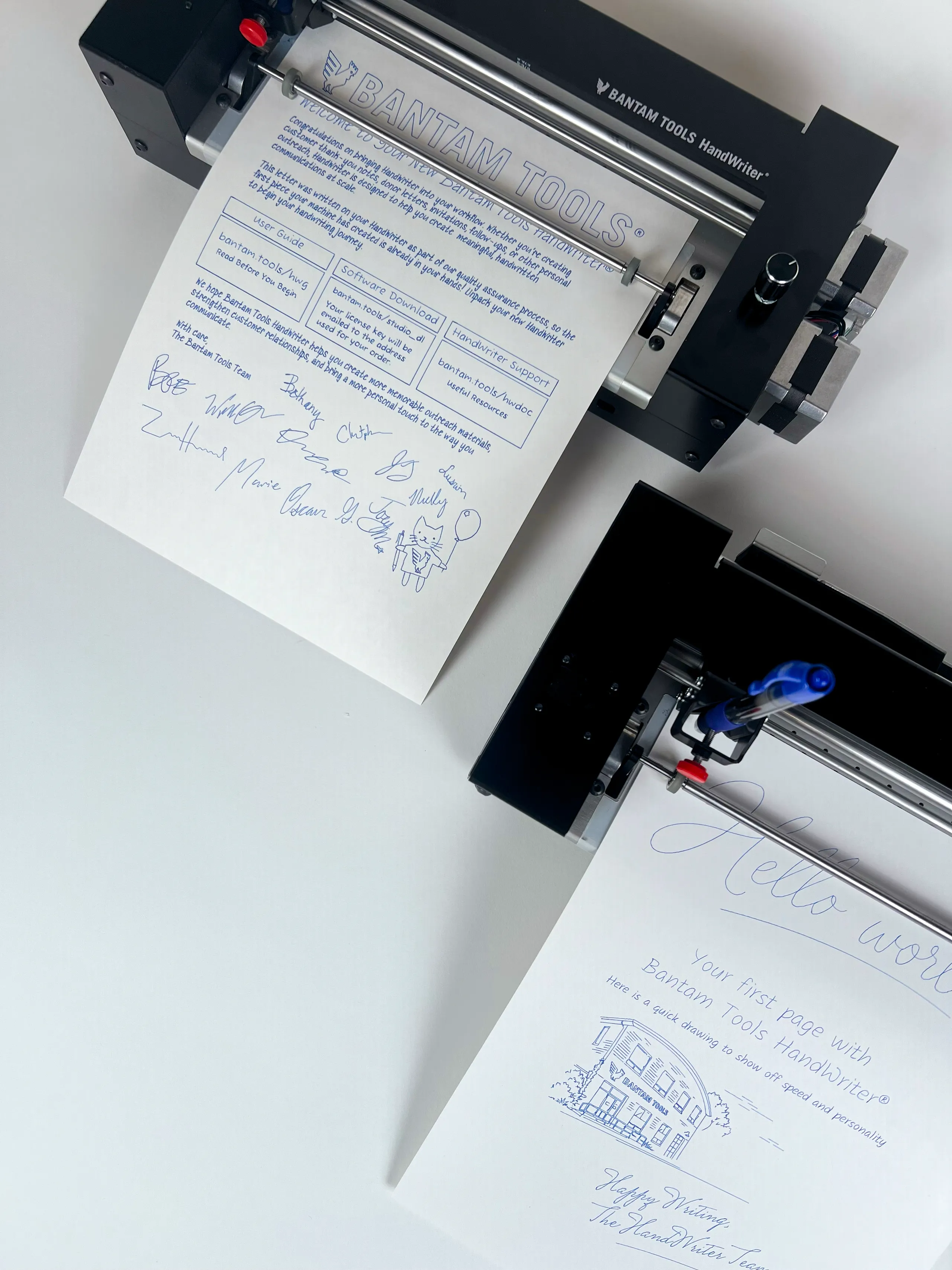 Overhead view of two Bantam Tools HandWriter® machines with handwritten welcome and sample pages
