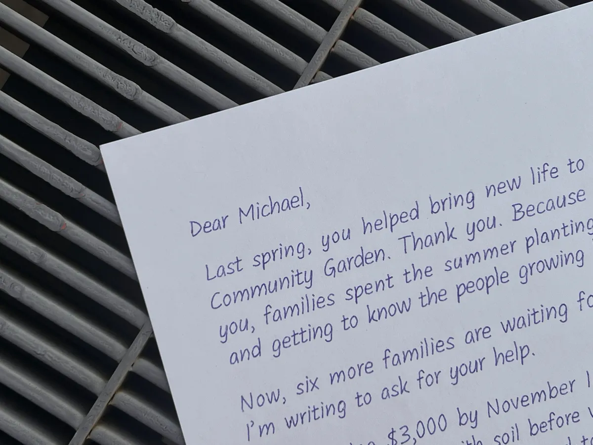 Close-up of a handwritten donor thank-you letter addressed to Michael on a metal slatted surface