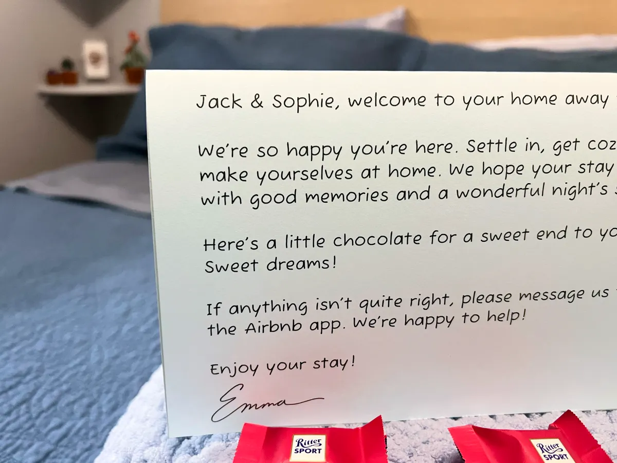 Personalized handwritten welcome letter for Jack and Sophie on a guest bed with chocolates